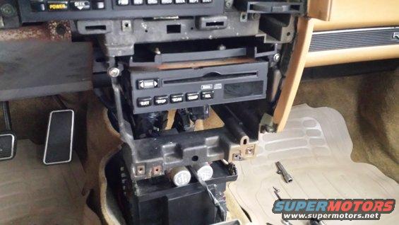 1991 Buick Reatta interior dashboard with radio and trim removed, showing pedals and floor mat