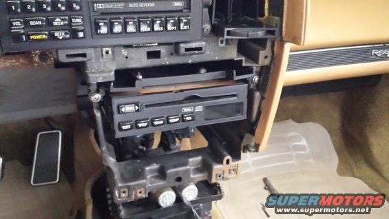 Car interior dashboard, stereo removed, tan trim, 'Reatta' badge visible
