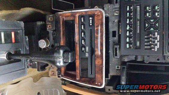 1991 Buick Reatta interior showing woodgrain trim around the gear shifter and radio controls