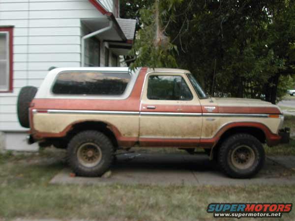 Side view of a two-tone 1979 Ford Bronco with a spare tire on the back