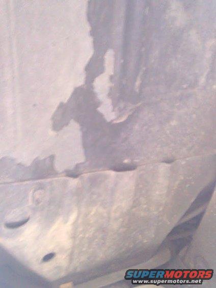rusted metal panel with circular holes and a torn edge, Supermotors.net logo at bottom right