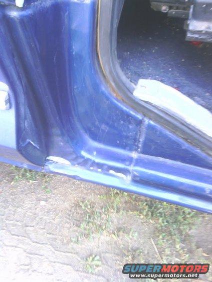 Blue vehicle door jamb with visible rust and damage