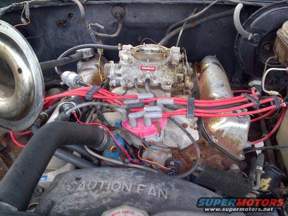 Engine bay with carburetor and red spark plug wires