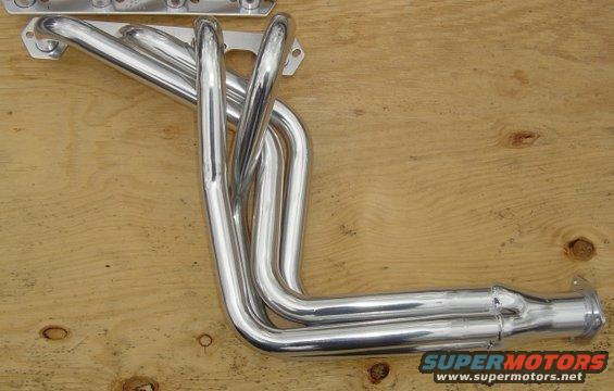 chrome exhaust headers on a wooden surface