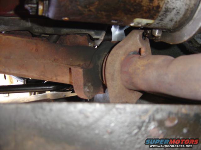 close-up of rusty exhaust pipe connection under a vehicle