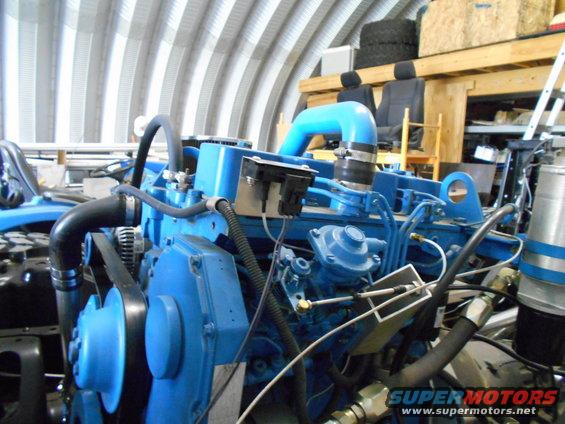 Blue engine assembly with hoses and belts, in a workshop