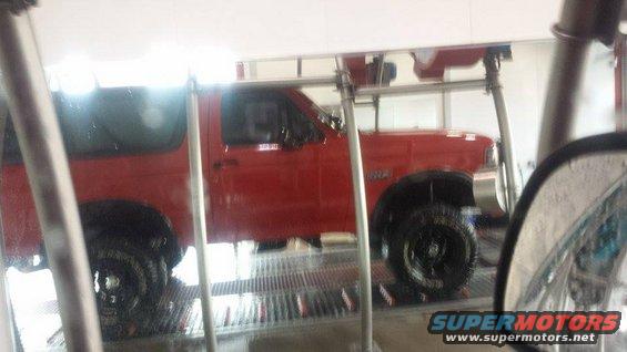 Side view of a red 1995 Ford Bronco at a car wash