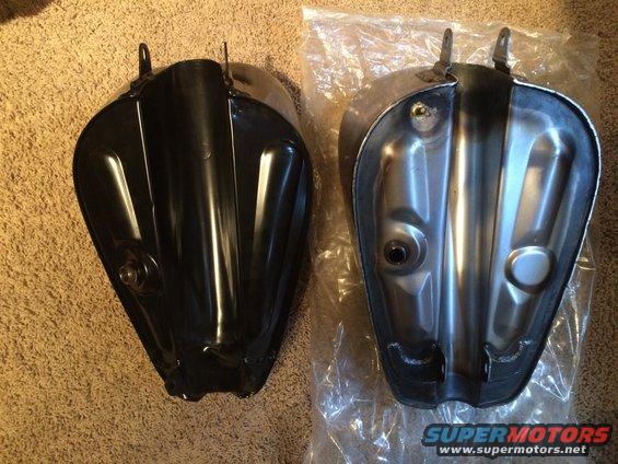 Two black and silver motorcycle fuel tanks side-by-side on a carpeted surface