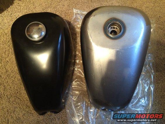 Two motorcycle fuel tanks, one black with a chrome cap, the other unpainted metal with a fuel cap opening