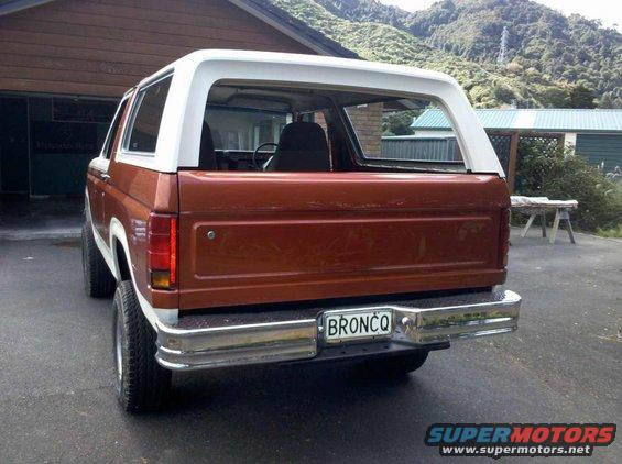 Brown and white Ford Bronco rear view with BRONCO license plate