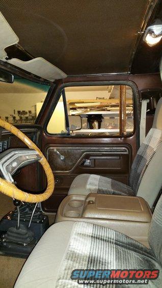 1979 Ford Bronco interior showing plaid seats, brown door panel, and steering wheel