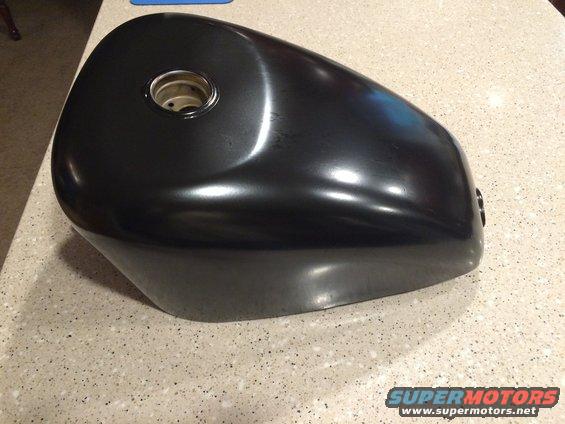 Black motorcycle gas tank with a metal ring on top