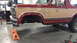 1984 Ford Bronco - This two-tone red and tan 1984 Ford Bronco is shown on jack stands, likely for maintenance or repair.
