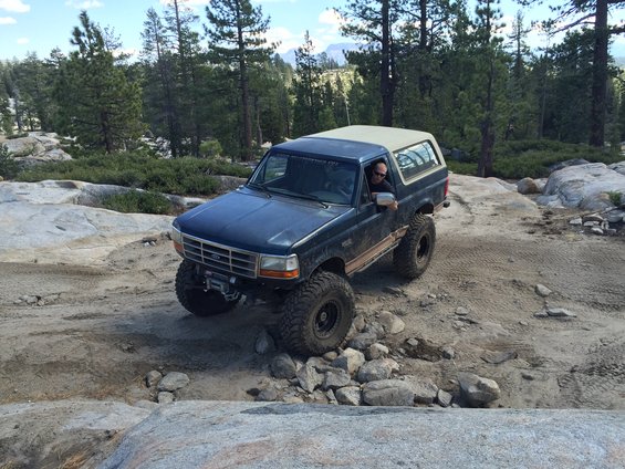 Dark blue SUV with tan top navigating rocky terrain
