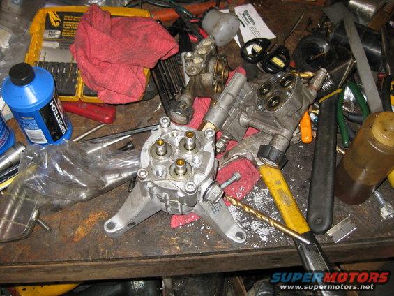 Pressure washer pump parts and tools on a workbench