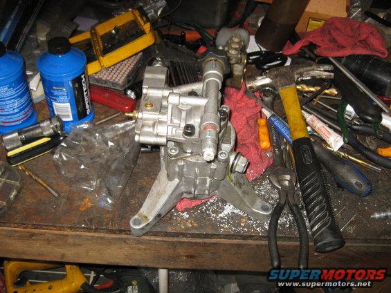 Silver pressure washer pump on a workbench with tools