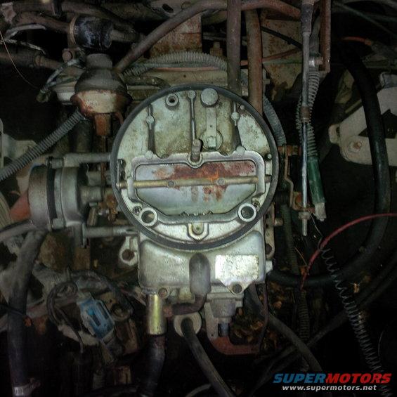 Carburetor with rusty components and surrounding engine parts