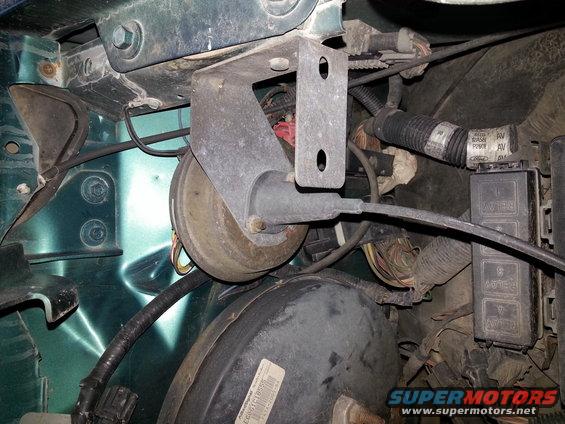 Close-up of brake booster and wiring harness in a vehicle engine bay