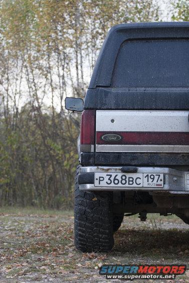Dark blue and silver Ford Bronco rear with a chrome bumper and Russian license plate