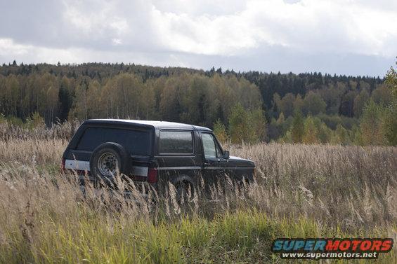 1987 Ford Bronco in tall grass, rear quarter view