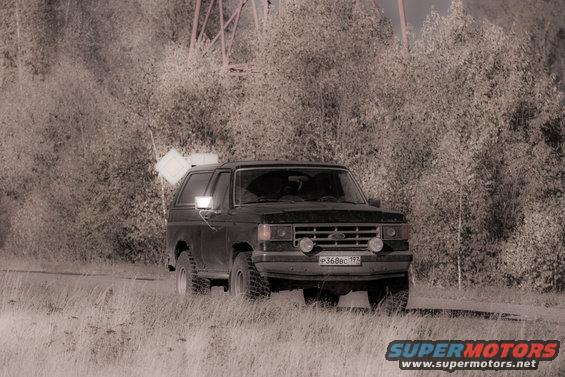 Black 1987 Ford Bronco with aftermarket lights and a license plate