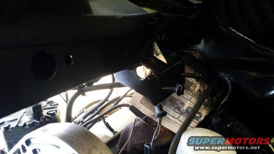 Undercarriage of a vehicle with black painted frame and visible hoses and wires
