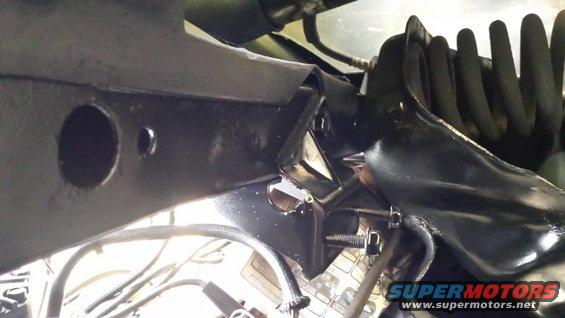 Black suspension part with coil spring and mounting bolts