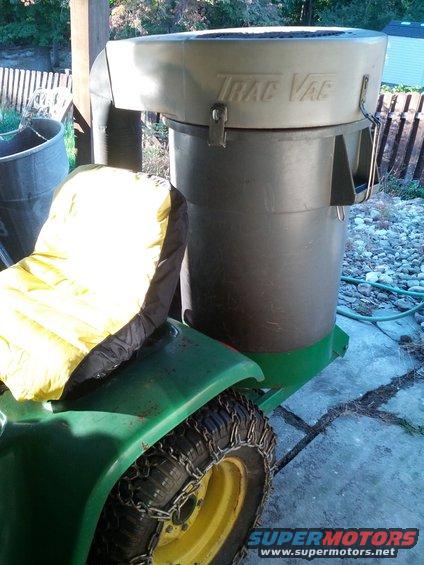Trac Vac leaf collection system on green tractor with tire chains