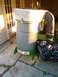 1982 Kubota RTV900 - A Trac Vac leaf vacuum unit is shown with a collection bag, positioned outdoors on a patio.