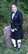 2003 Ford Crown Victoria - A man dressed in traditional Scottish attire stands in a grassy area with trees in the background.