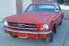 1965 Ford Mustang - Front view of a red 1965 Ford Mustang coupe with a chrome bumper and grille.