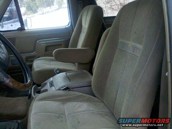 Front seats and center console of a truck. The seats are tan cloth with a patterned stripe