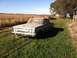 1964 Mercury Comet - A weathered 1961 Mercury Comet sedan sits abandoned in a rural setting under a clear blue sky.
