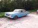 1964 Mercury Comet - A blue 1964 Mercury Comet sedan sits parked on a concrete driveway with trees in the background.