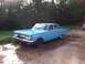 1964 Mercury Comet - This blue 1964 Mercury Comet sedan is parked on a wet driveway with trees in the background.