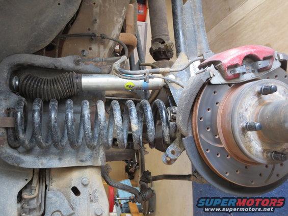 Rear suspension with Bilstein shock and coil spring, red brake caliper