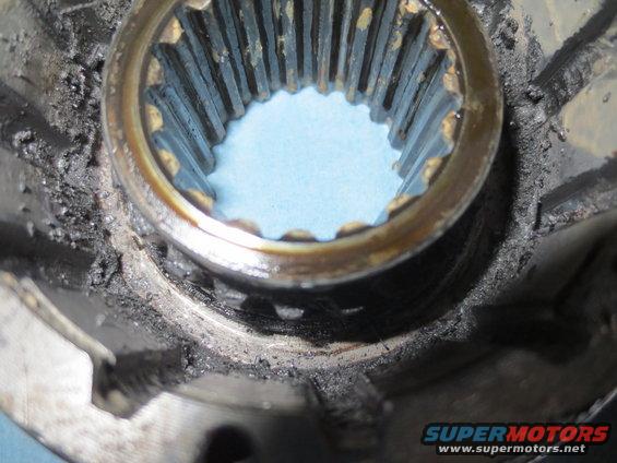 Close-up of a splined hub with grease and debris. Supermotors.net logo visible