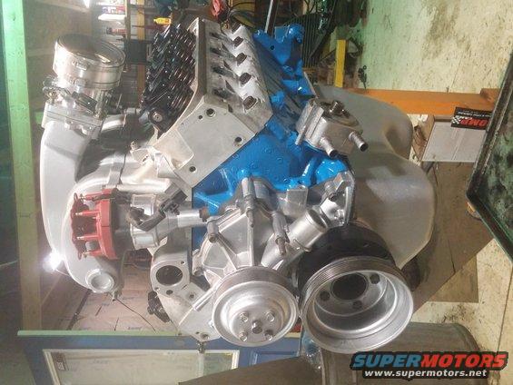 V8 engine with blue intake manifold, silver air cleaner, and red distributor cap