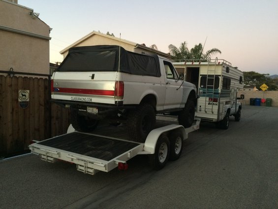 White lifted Bronco on trailer, rear view. Classracing.com visible
