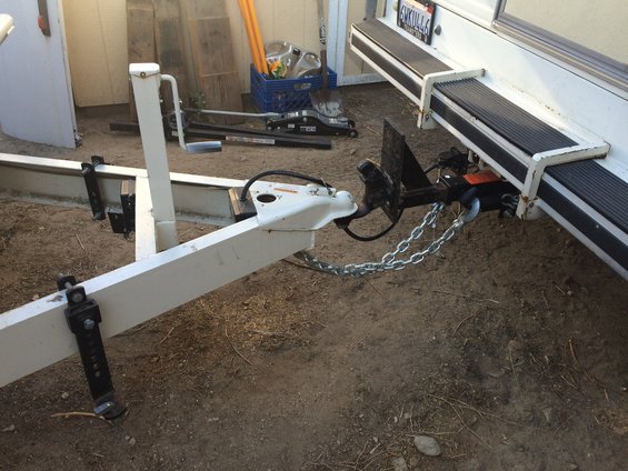 Trailer hitch and safety chains attached to a vehicle bumper
