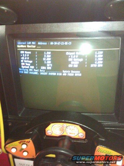 Arcade game dashboard showing computer boot screen with hardware monitor data