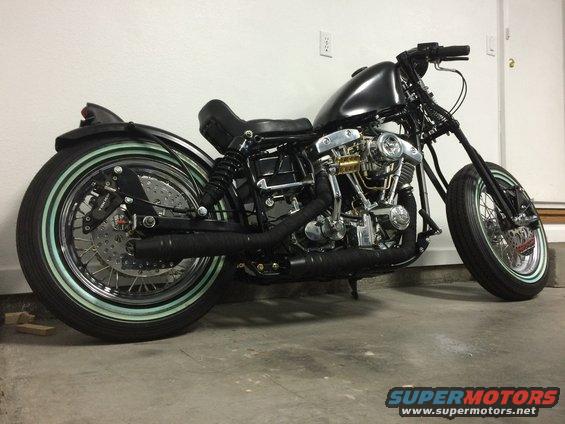 Black custom motorcycle with whitewall tires and exposed engine