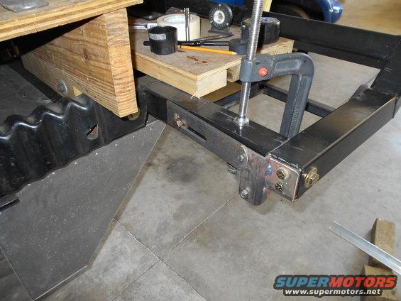 Close-up of vehicle frame with clamp and wooden supports