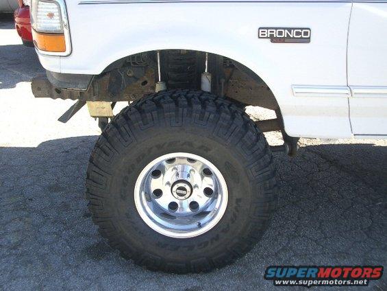 White 1994 Ford Bronco front fender and large off-road tire, showing "BRONCO" badge