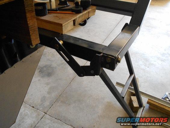 metal frame with wooden block and tools on top, concrete floor