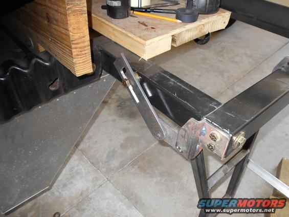 Metal bracket attached to black metal frame with wood above