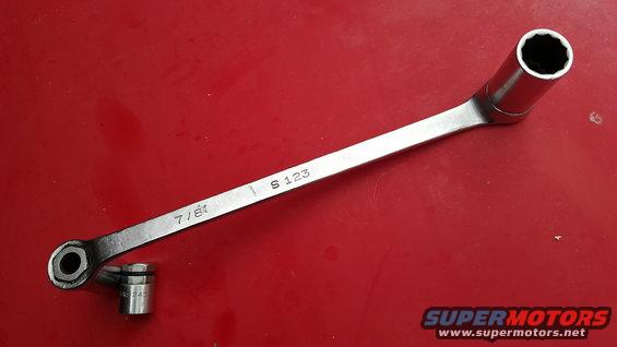 7/8 inch socket wrench with a 12mm socket attached, on a red surface