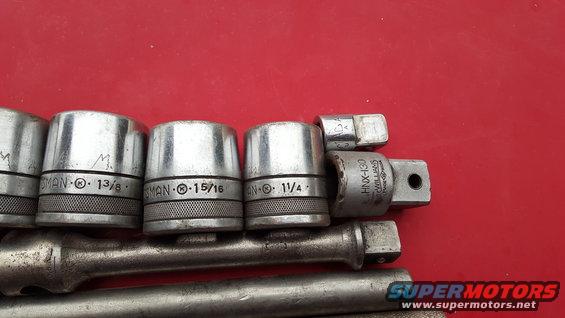 Socket wrench set with various sizes including 13/8, 15/16, and 11/4 inches on a red background