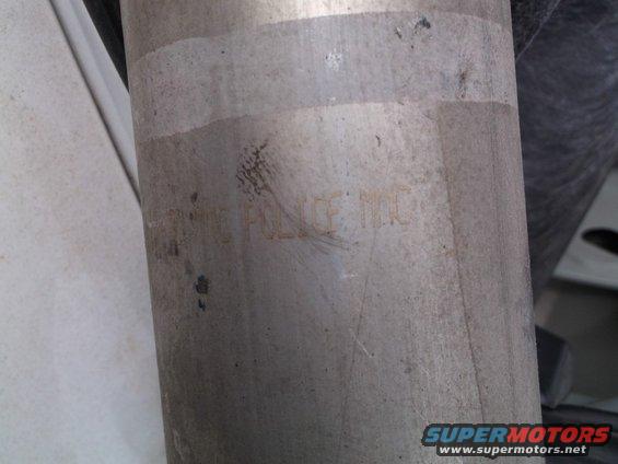 Metal exhaust pipe with stamped text "POLICE INC"