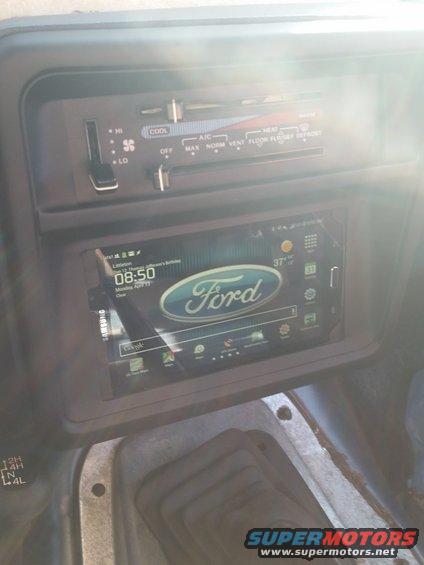 1988 Ford Bronco interior showing dashboard with climate controls and a modern touchscreen display with Ford logo